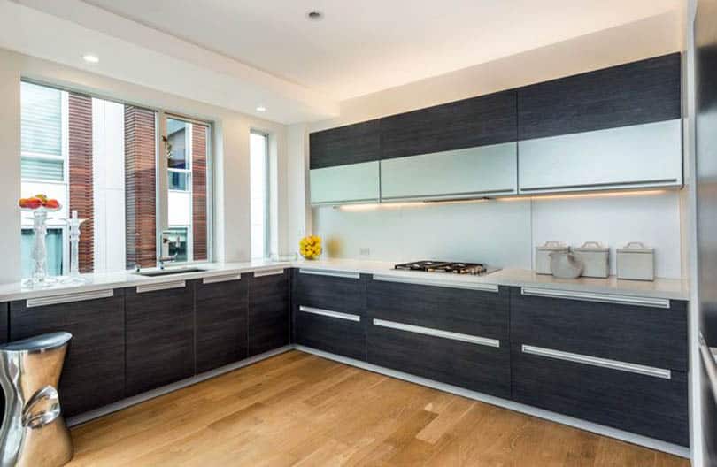 Modern kitchen with dark gray european cabinets with c channel door hardware
