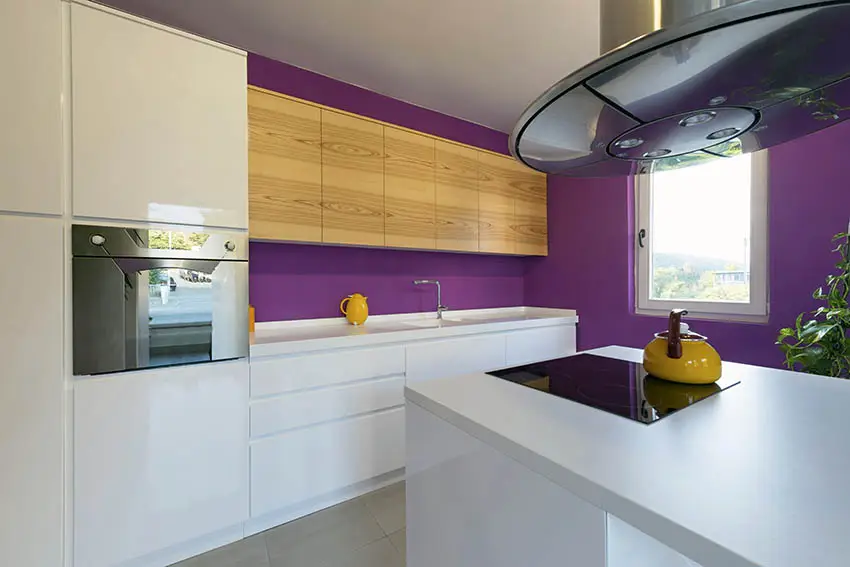 Modern kitchen with white cabinets purple paint color and small island