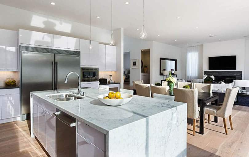 Modern kitchen with white high gloss cabinets and waterfall marble island