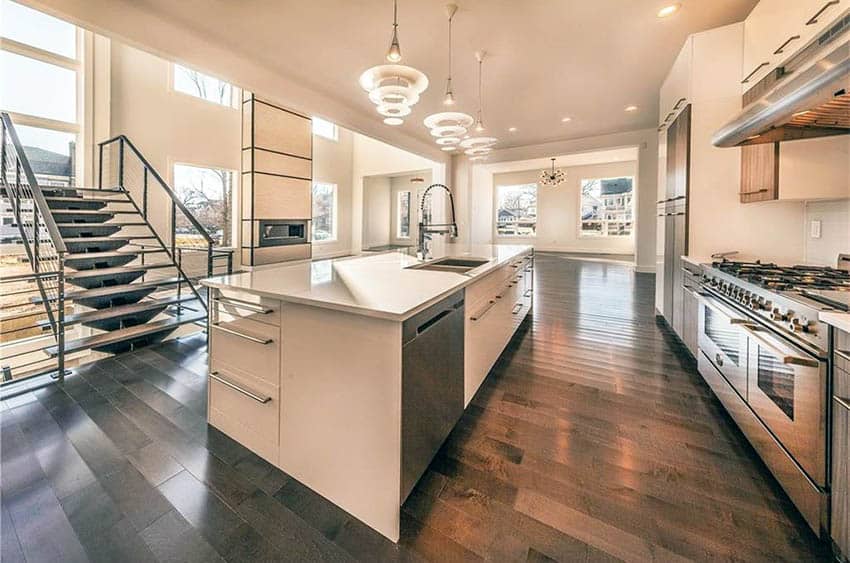 Open kitchen with glossy cabinets, looped pendant lighting and double ovens