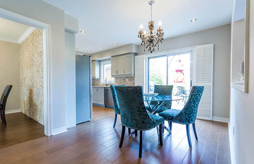 Room with glam candle type chandelier and gray cabinets