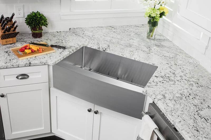 Stainless steel apron sink in corner of kitchen