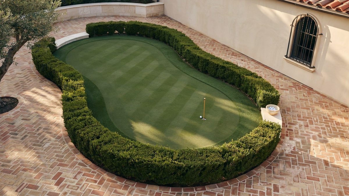 Boxwood outlined green shaped into brick paving at a Mediterranean home
