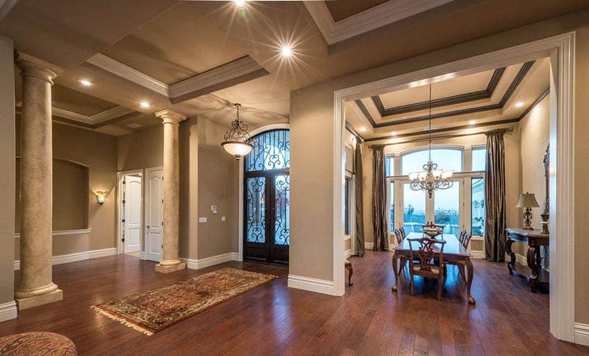 House entryway with beige paint and hardwood flooring with recessed sconce chandelier and pendant lights
