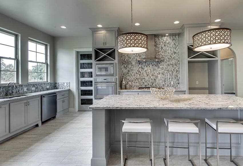 Kitchen with light gray cabinets, white granite countertops and drum pendant lights