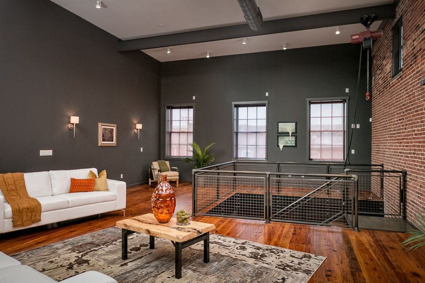 Loft living room with wood floors high ceiling and black painted walls