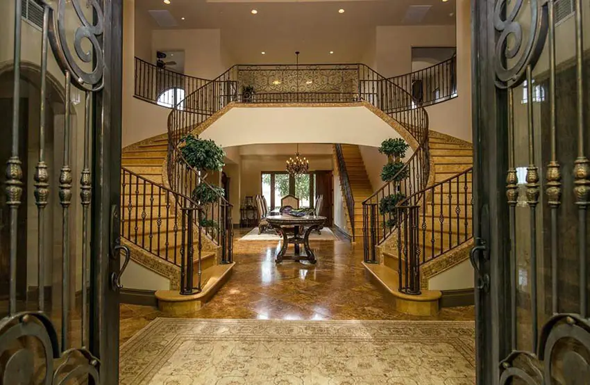 Luxury foyer entry with dual staircase metal front doors and brown paint