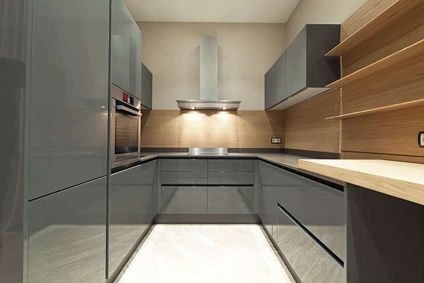 Modern kitchen with dark gray high gloss acrylic cabinets wood backsplash and gray quartz countertop