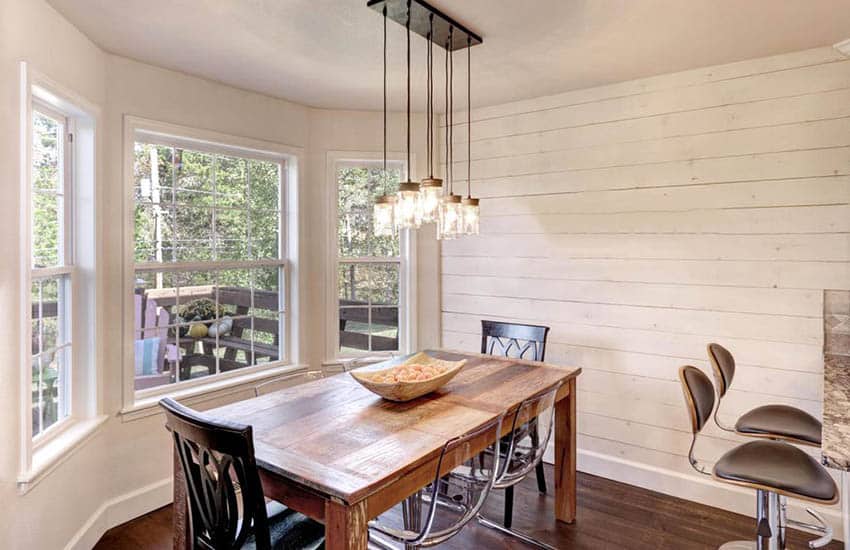 Rustic dining room with painted shiplap wall and wood table
