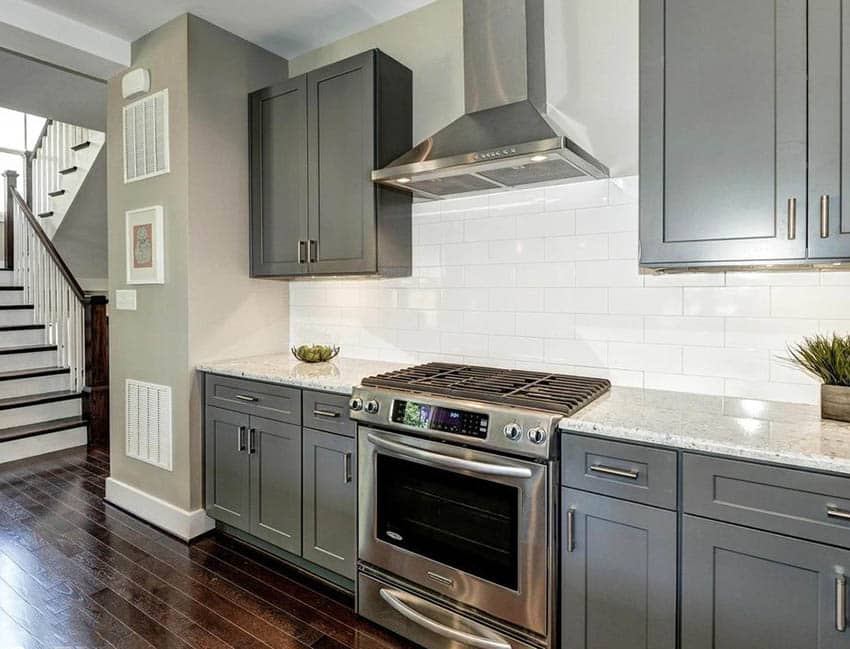 Single wall kitchen with gray cabinets and large white subway tile backsplash