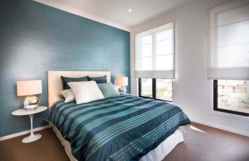 Bedroom with green wallpaper and green bed linens