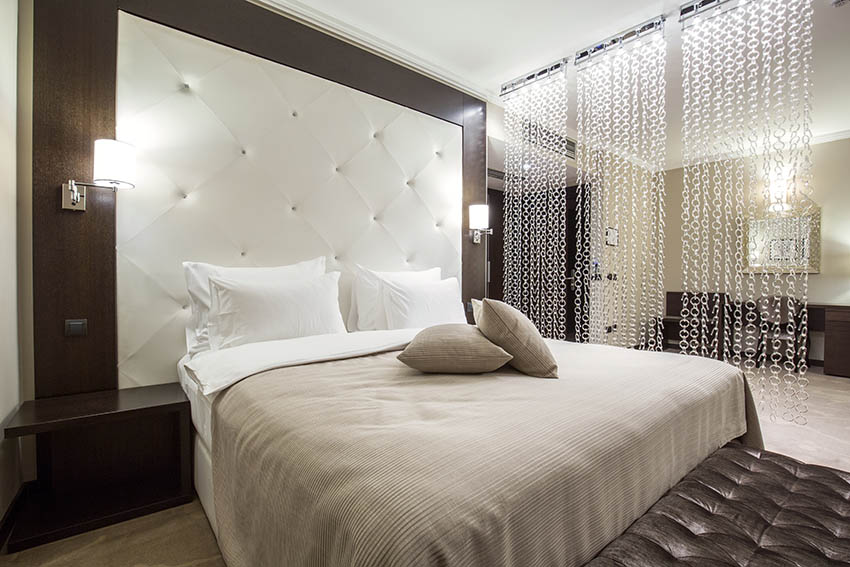 Bedroom with large white tufted headboard