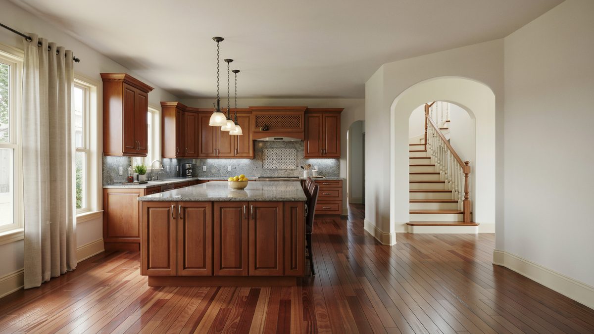 Cherry kitchen open to hallway with arched doorway and curved staircase beyond