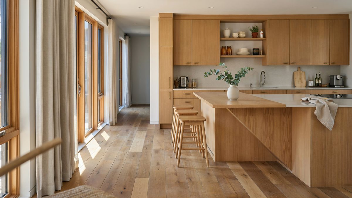 Oak laminate flooring in a warm wood kitchen with a long breakfast bar island