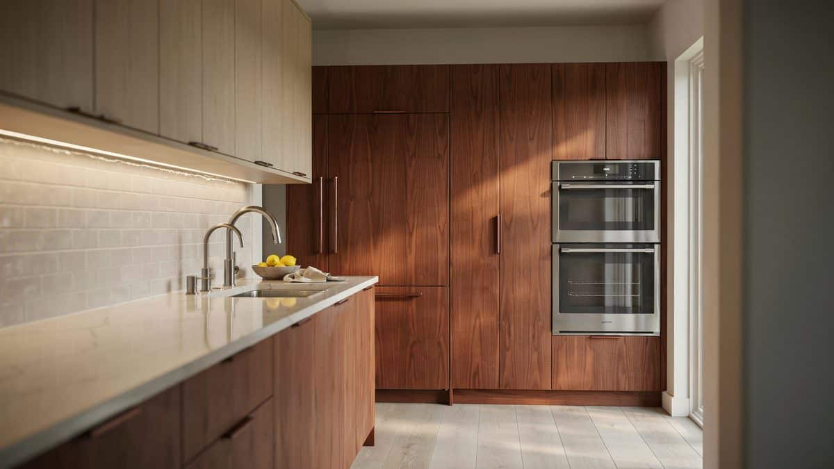 Cherry pantry wall with built in wall ovens and pale stone counters