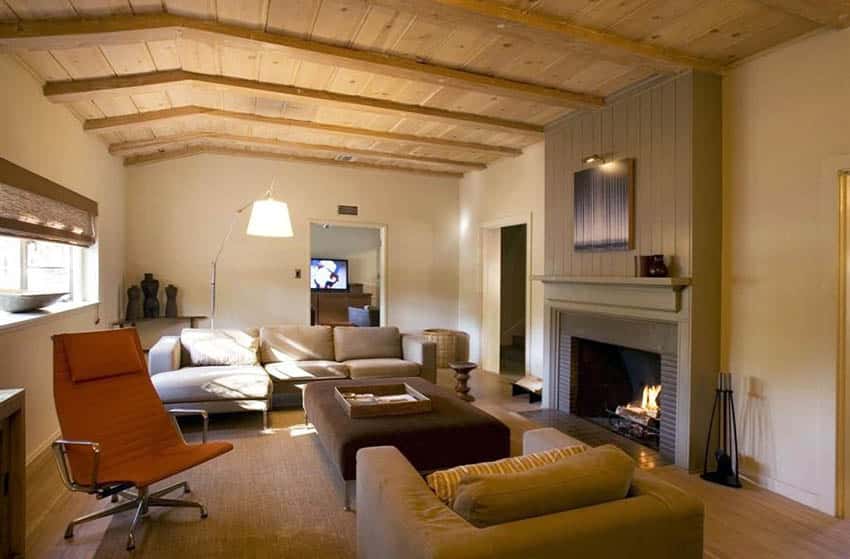 Contemporary living room with earth tone paint sloped wood ceiling bamboo flooring and fireplace