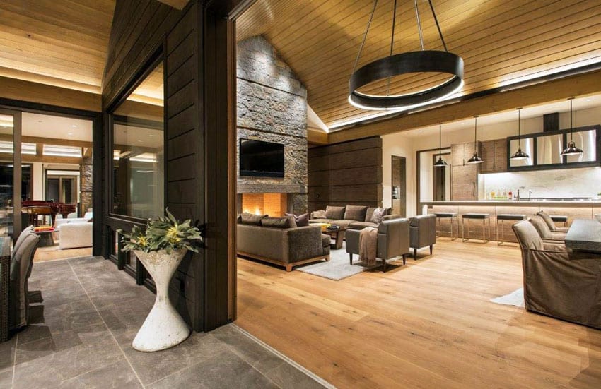 Contemporary living room with high vaulted ceiling and wood accents stone fireplace