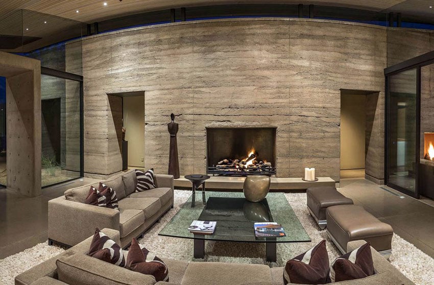 Contemporary living room with stone wall concrete flooring wood slat ceiling and tan furniture