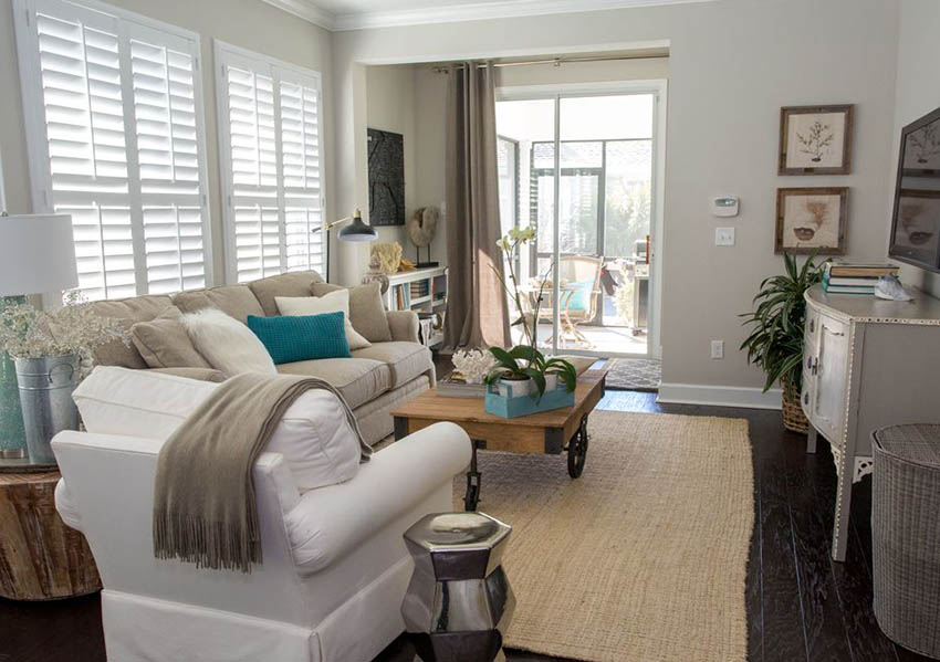 Room with windows with blinds, white couch and potted plant