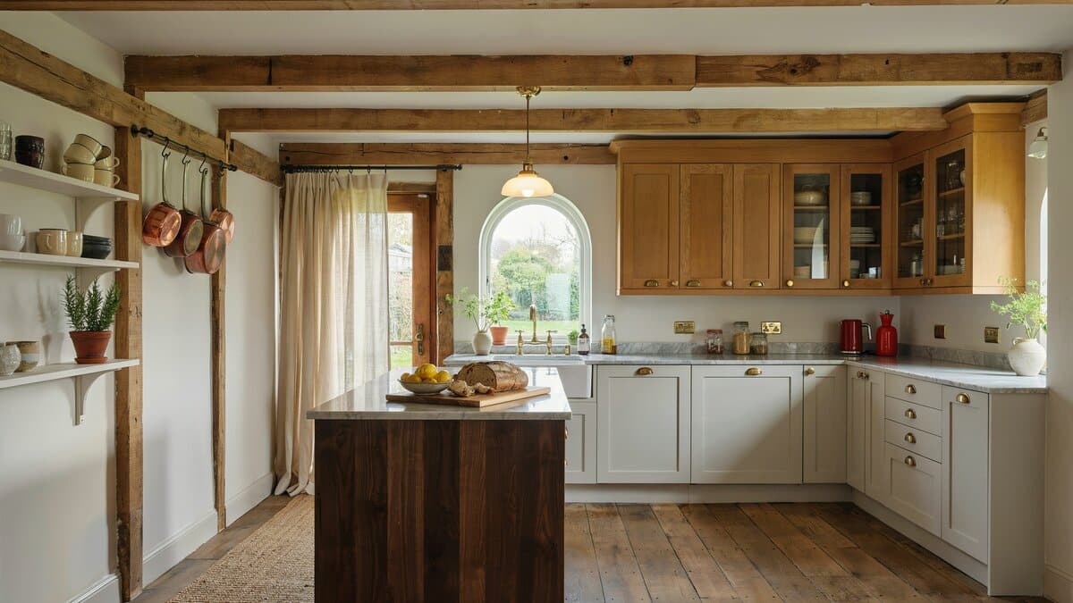 Golden oak glass front cabinets beside white cabinets and a dark timber island