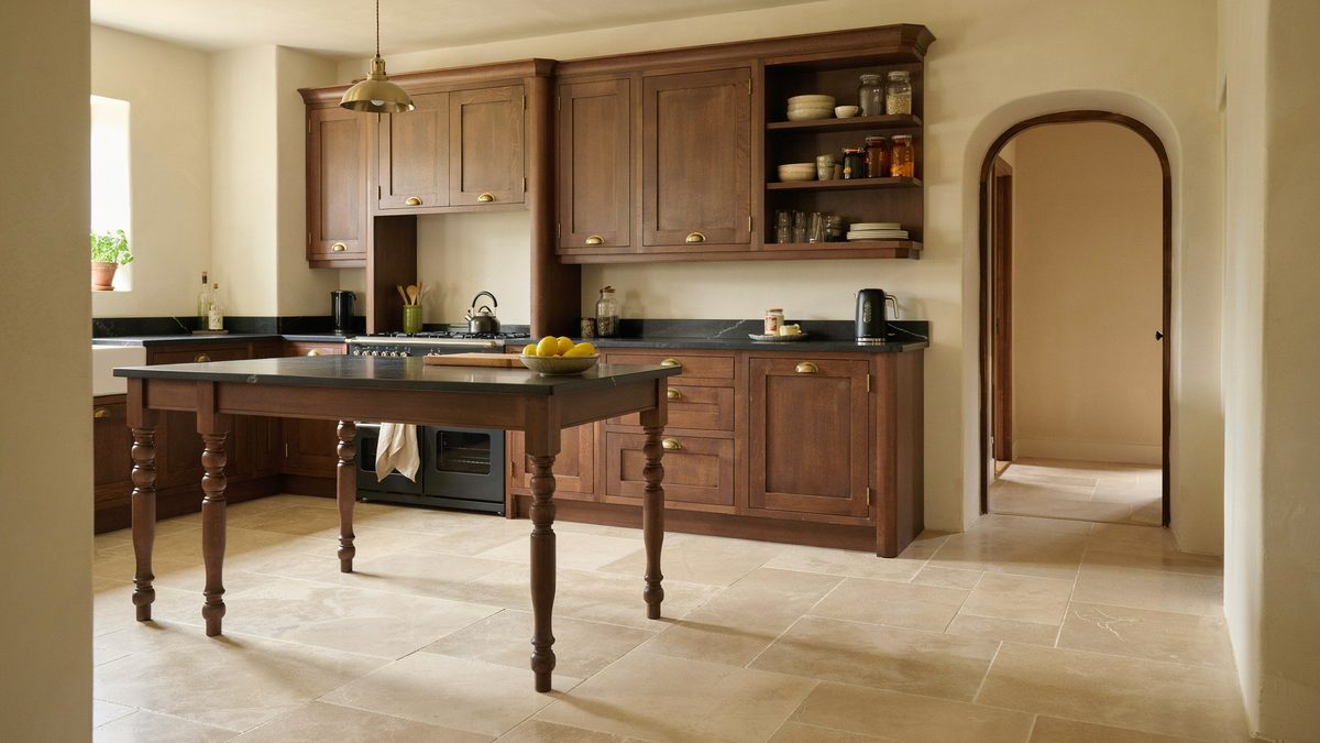 Cherry kitchen with turned leg dining island black counters and arched doorway