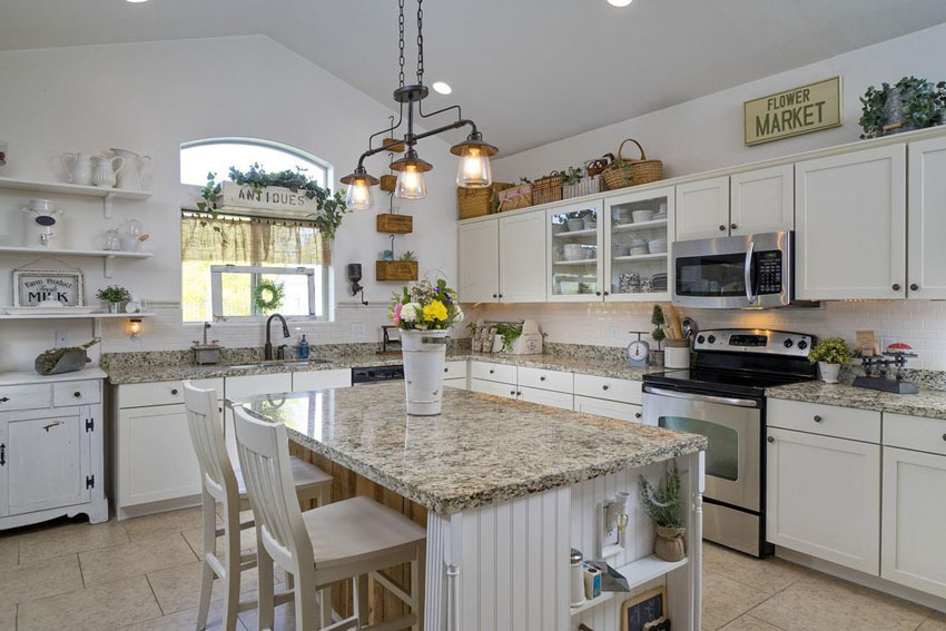 Eclectic kitchen with signs and decor above white cabinets and beadboard island