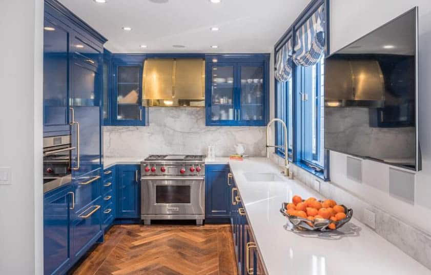 Kitchen with printed blue curtains, Carrara marble backsplash and bronze hood