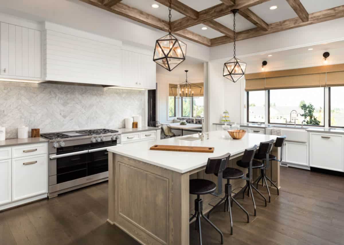 kitchen with island carrara marble backsplash ceiling beams and windows
