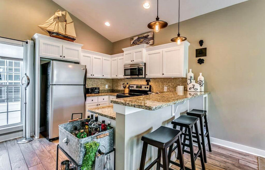 Kitchen with nautical decor above cabinets and breakfast bar peninsula