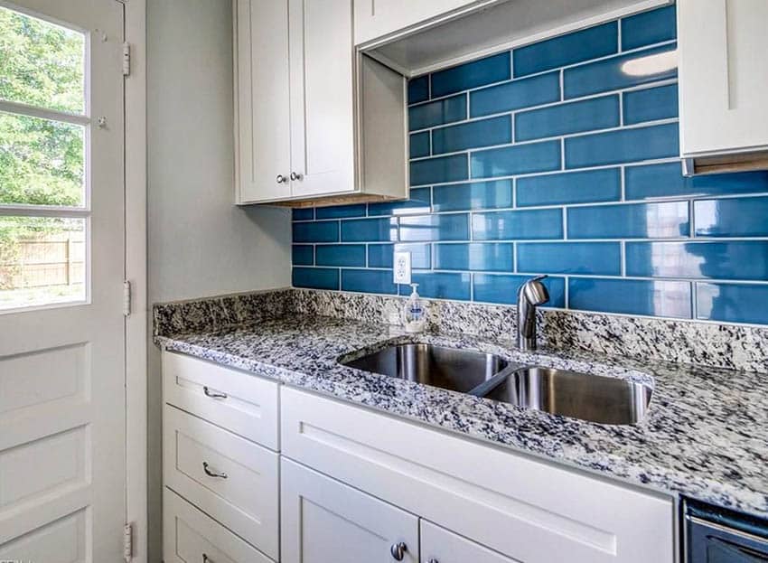 Kitchen with white cabinets and long blue subway tile backsplash