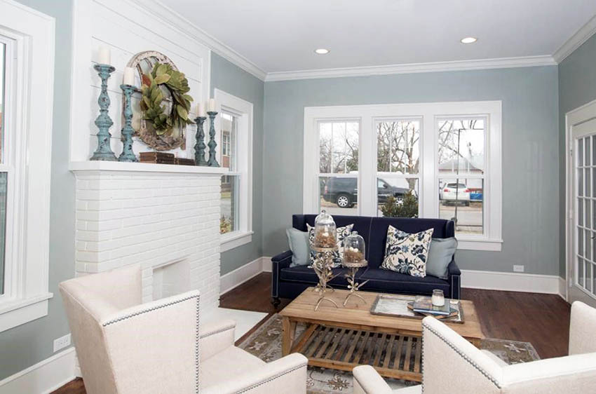 Light gray and white living room with painted brick fireplace and wood flooring