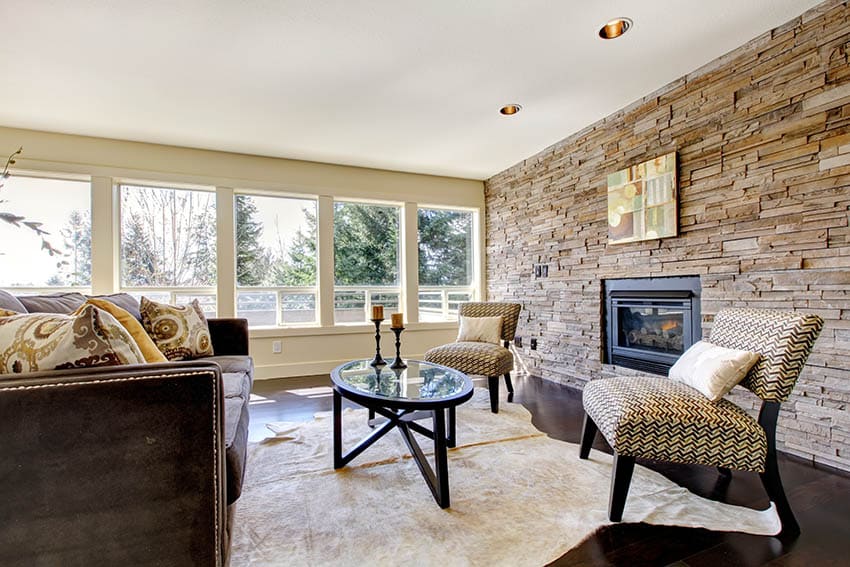 Living room with beige walls and stacked stone accent wall with fireplace