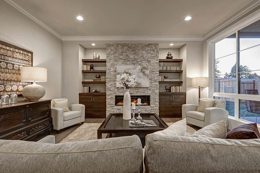 Living room with griege painted walls wood built in bookshelves and stone fireplace