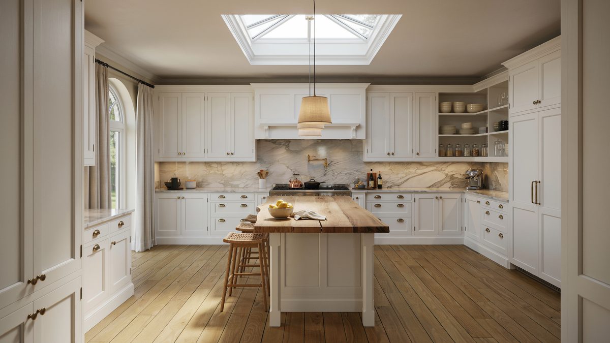 Skylight pours daylight onto a wood topped island in a white kitchen