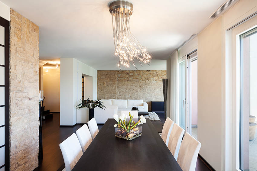 Modern dining room with stone accent wall and branch cluster pendant light