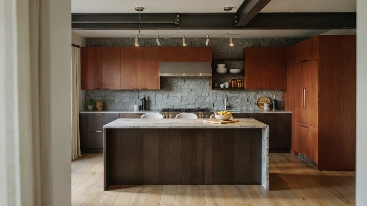 Industrial cherry kitchen with track lighting open shelving and pale stone island