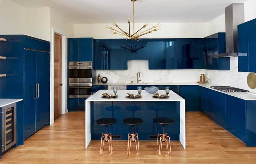 Modern kitchen with glossy blue cabinets and white quartz backsplash and countertops