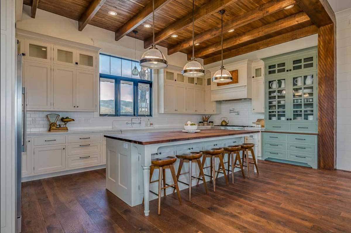 spacious kitchen with timber frame exposed ceiling beam and stools