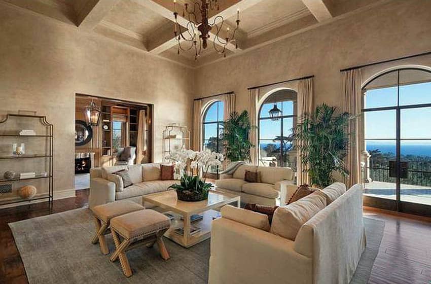 Traditional living room with light brown paint wood floors cream couches and chandelier