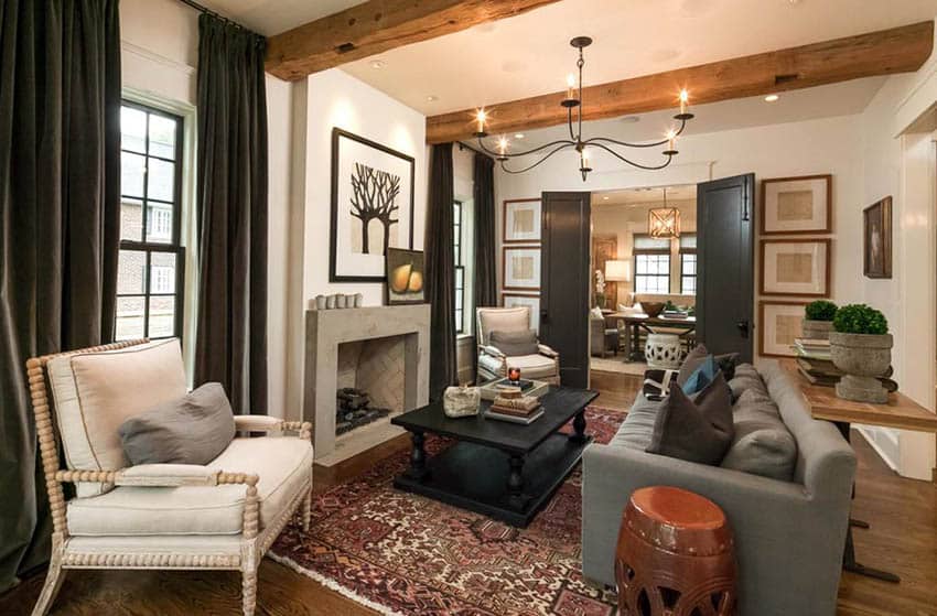 Warm living room with earth tone colors concrete fireplace and rough wood beams