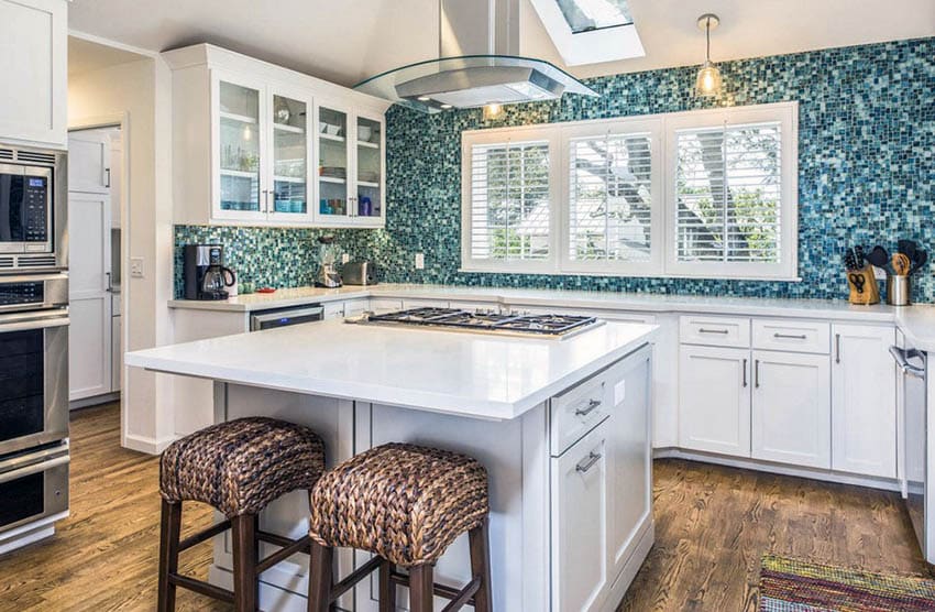 White kitchen cabinets with blue mosaic tile backsplash and white quartz countertop