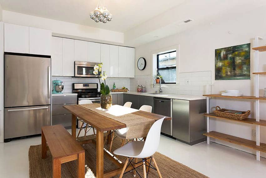 Contemporary kitchen with silver and white cabinets with white subway tile and wood bench dining table