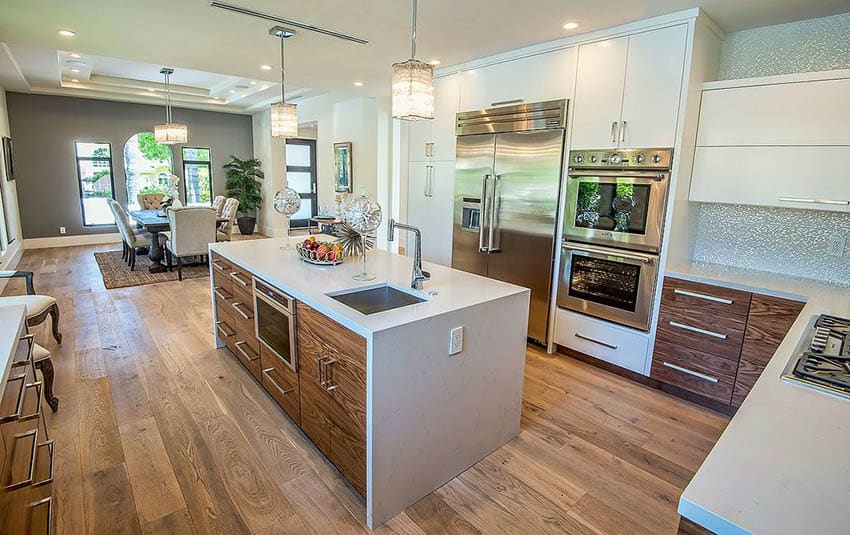 Contemporary kitchen with two tone brown and white cabinets and synthetic quartz waterfall island