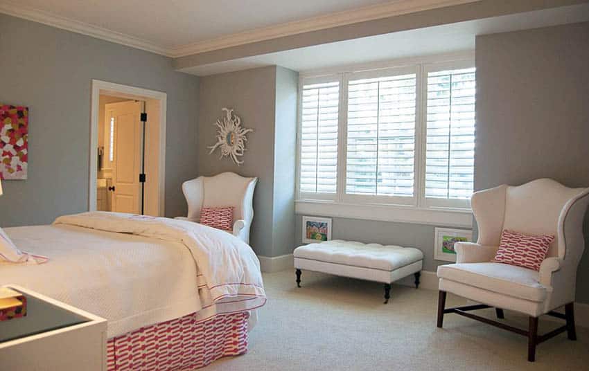 Cottage bedroom with two wing chairs and tufted storage bench