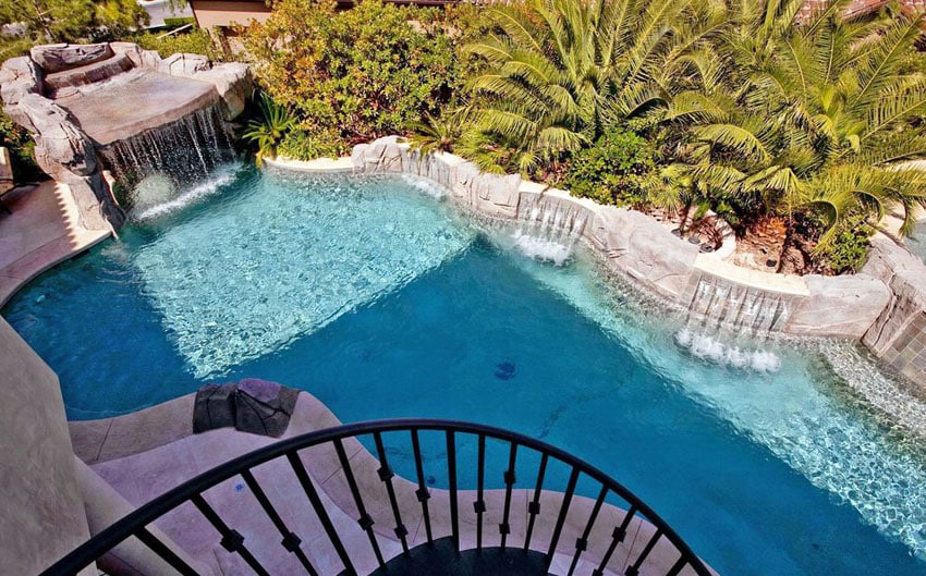 Custom swimming pool with multiple waterfalls and palm trees