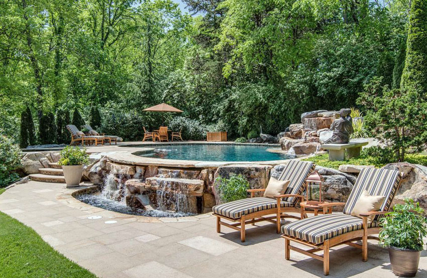Custom swimming pool with rock waterfall on the outside