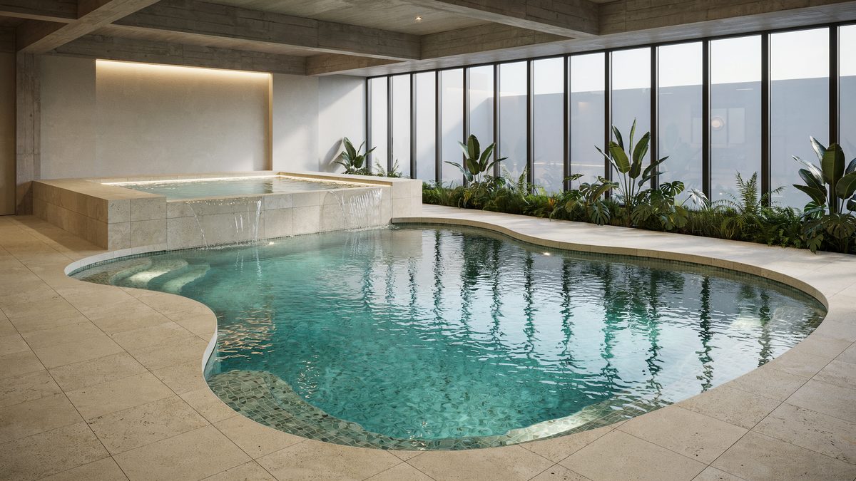Indoor freeform pool with an elevated spa spilling into turquoise water
