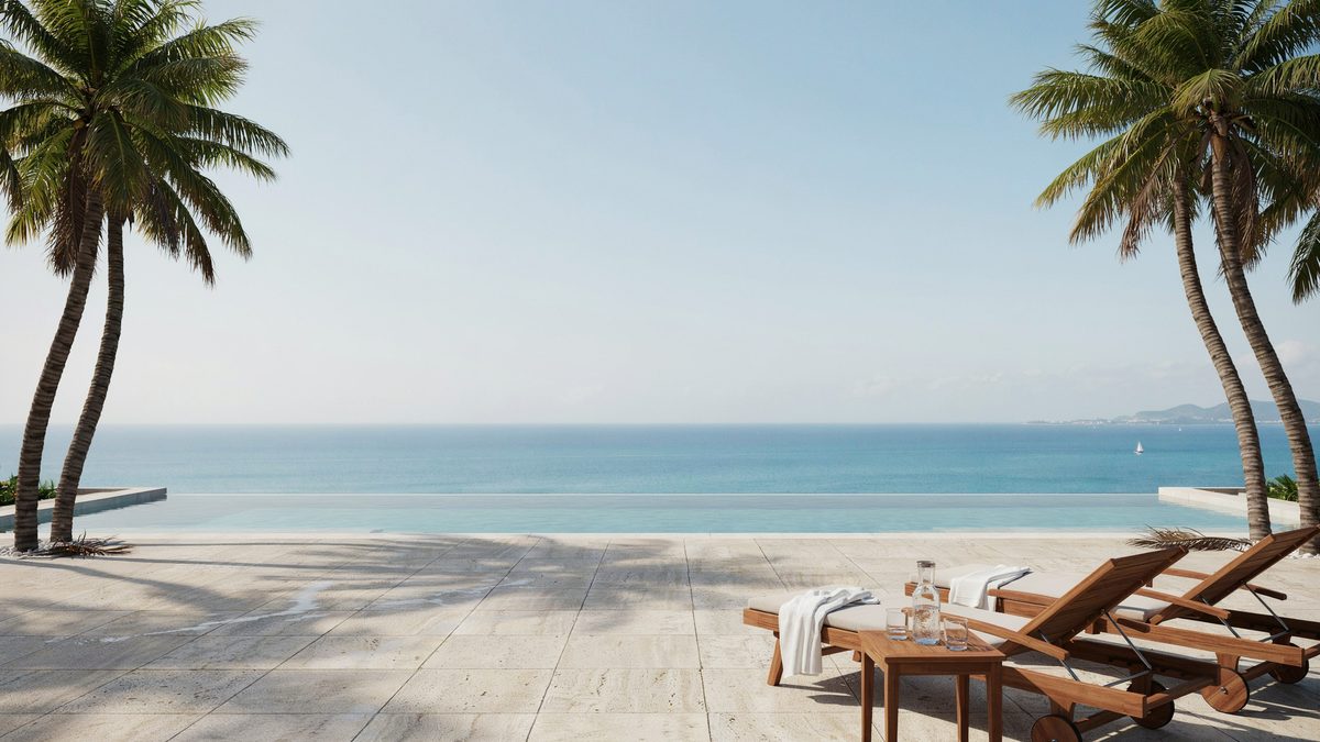 Vanishing edge pool framed by leaning palms above a calm blue ocean