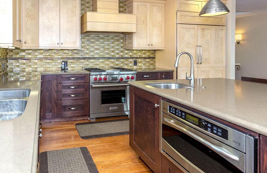 Kitchen with two shades of wood cabinets and metallic backsplash
