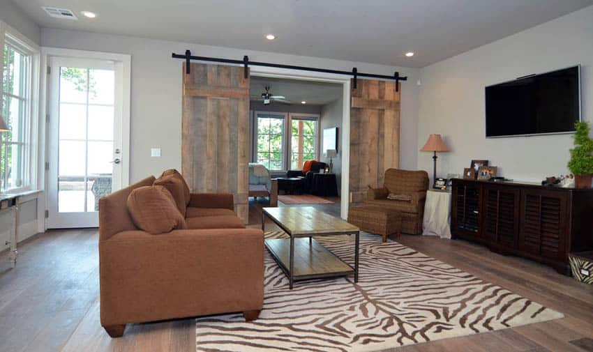 Room with white walls, brown couch and console table